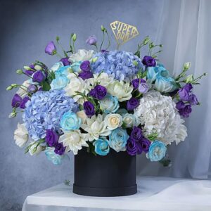 Super Dad floral arrangement with blue hydrangeas, white roses, and purple flowers in black box